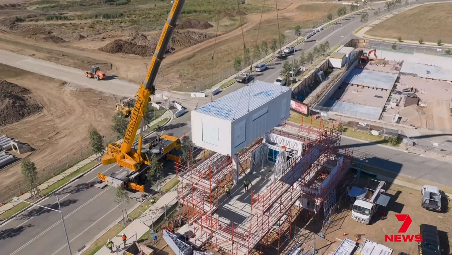 Crane lifting a prefabricated room module onto a prepared building at Cobbitty, from 7NEWS